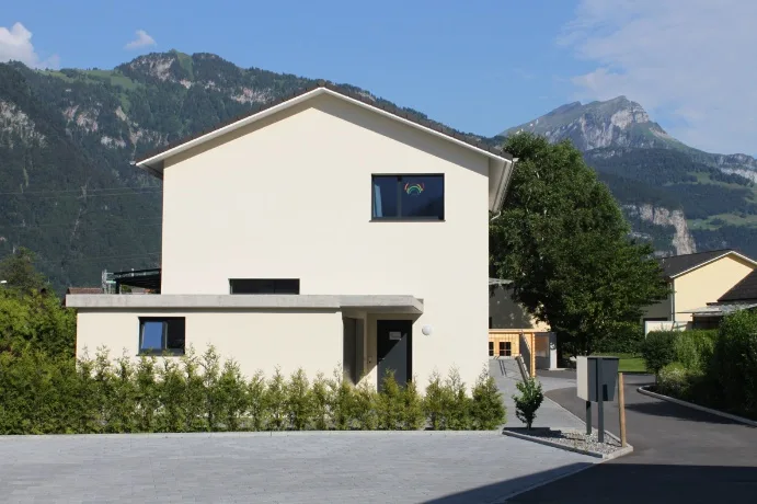 Praxis Aussenansicht mit Bergpanorama
